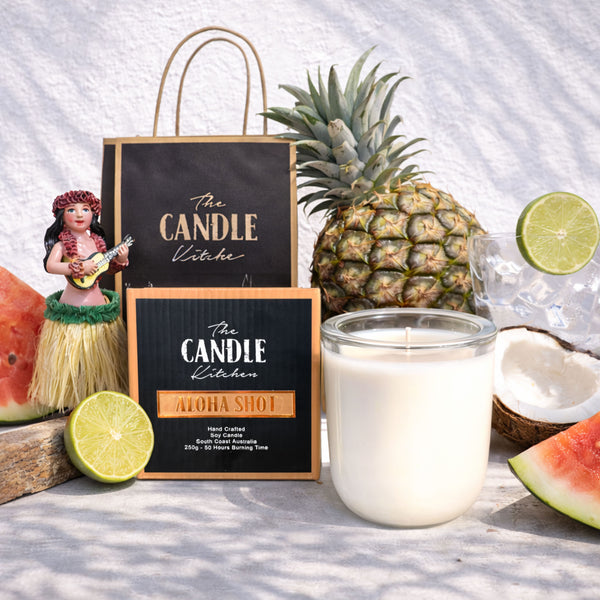 Aloha Shot soy candle The Candle Kitchen Candle with 'The Candle Kitchen' branding, pineapple, watermelon, and limes on a white background