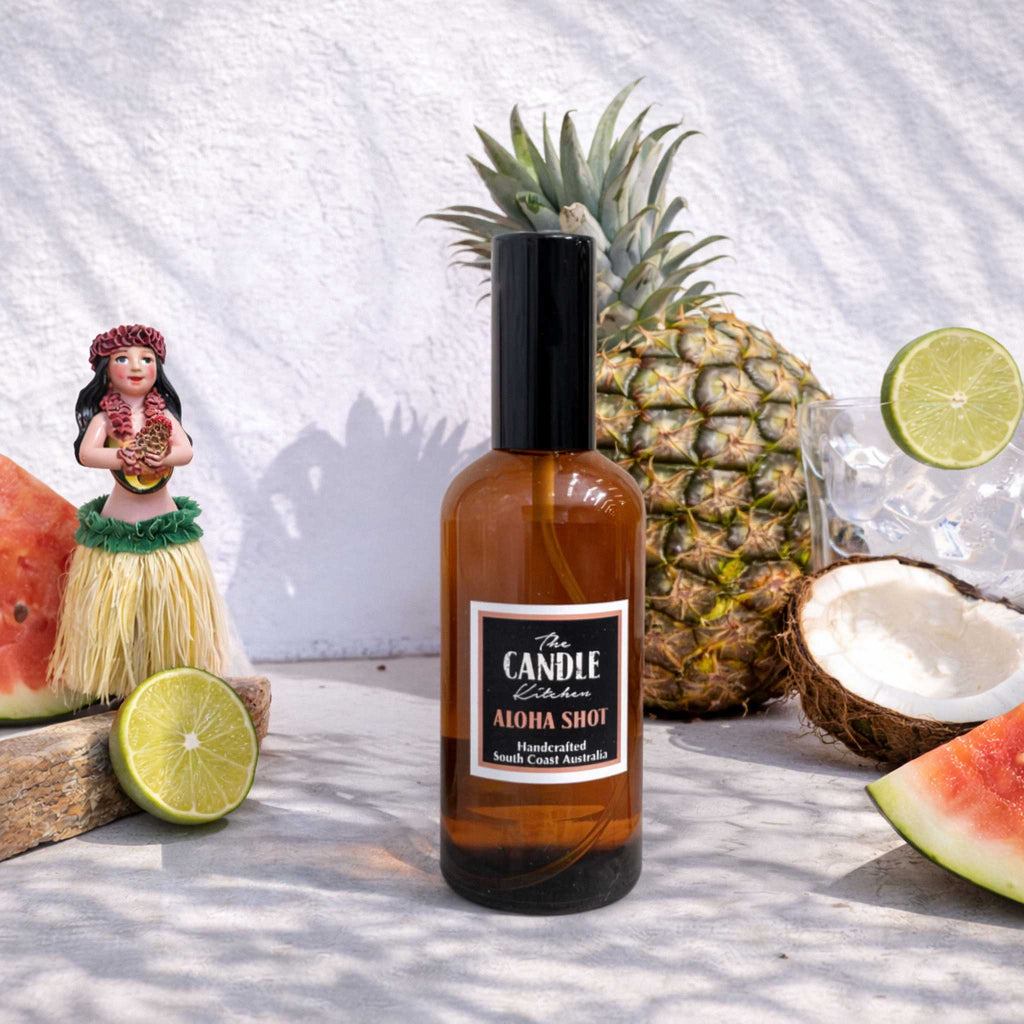 Bottle of 'The Candle Kitchen Aloha Shot' with pineapple, coconut, and watermelon on a white background