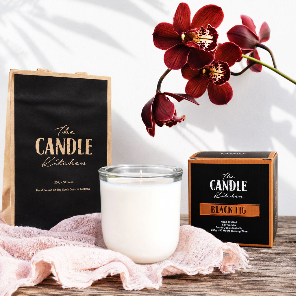 Black Fig Soy Candle with packaging and a red flower on a white background the candle kitchen