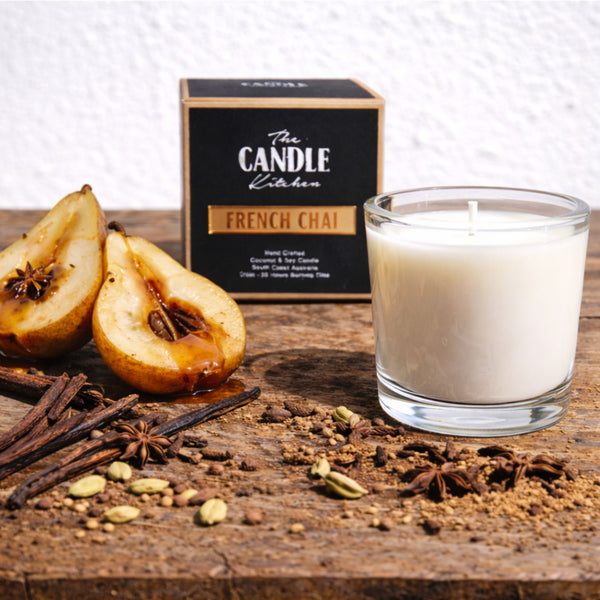French Chai Soy Candle Kitchen, Candle with 'The Candle Kitchen' packaging, pears, and spices on a wooden surface.