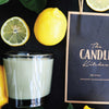 A Candle with lemons and 'The Candle Kitchen' bag on a dark surface.