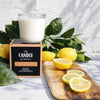 Lemoncello soy candle the candle kitchen on a cutting board full of juicy lemons and branches.