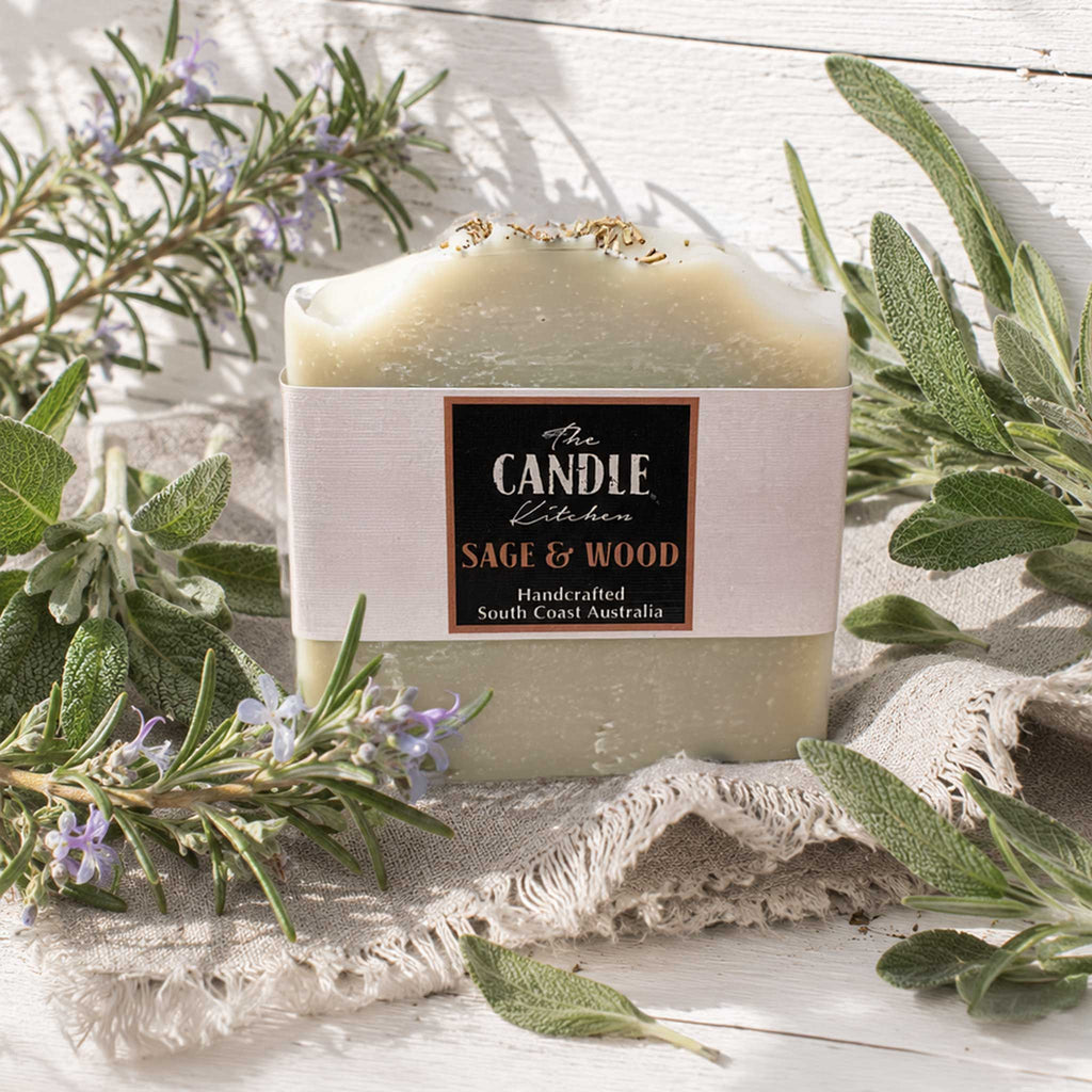 Sage and wood handmade soap surrounded by rosemary and sage on a linen tea towel